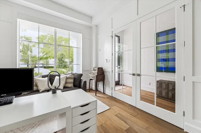 a living room with furniture a flat screen tv and a floor to ceiling window