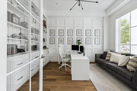 a living room with furniture a flat screen tv and a floor to ceiling window