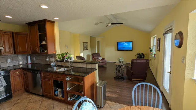 a view of kitchen island with stainless steel appliances granite countertop furniture and a sink