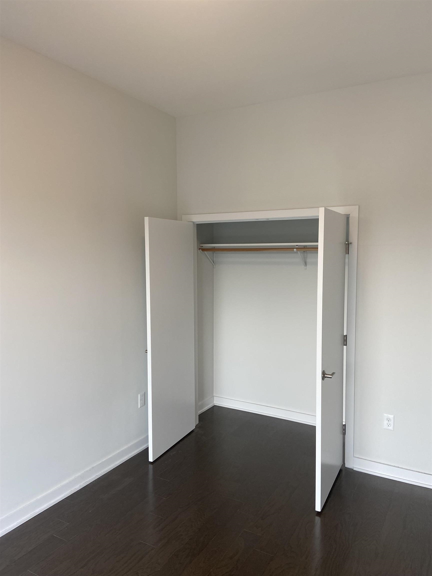 275 Broadway, Unit 302 Bayonne, NJ 07002 - Photo 5 of 13 an empty room with wooden floor