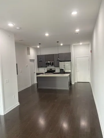 a view of kitchen with kitchen island stainless steel appliances sink and cabinets