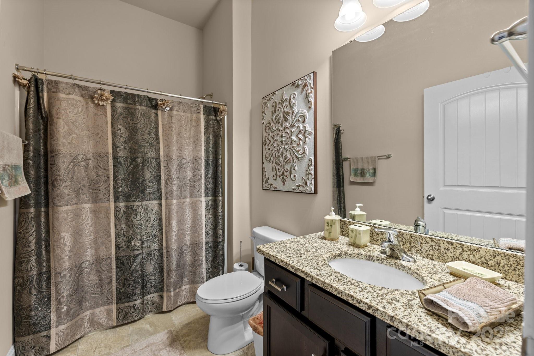 3006 Cricket Lane Lancaster, SC 29720 - Photo 20 of 28 a bathroom with a granite countertop sink toilet and shower