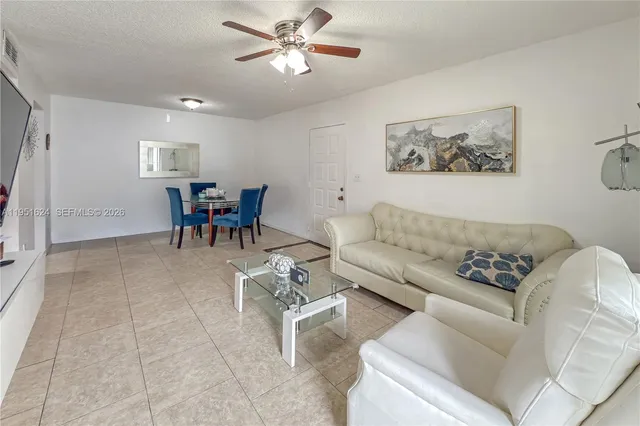 a living room with furniture and a view of kitchen