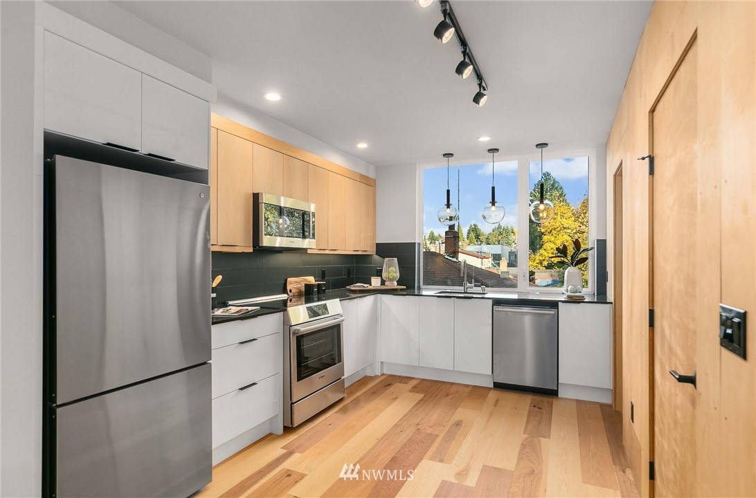 5202 Renton Avenue South Seattle, WA 98118 - Photo 7 of 10 a kitchen with stainless steel appliances granite countertop a refrigerator a stove a sink and a microwave