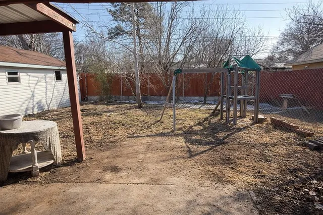 a backyard of a house with barbeque oven and outdoor seating