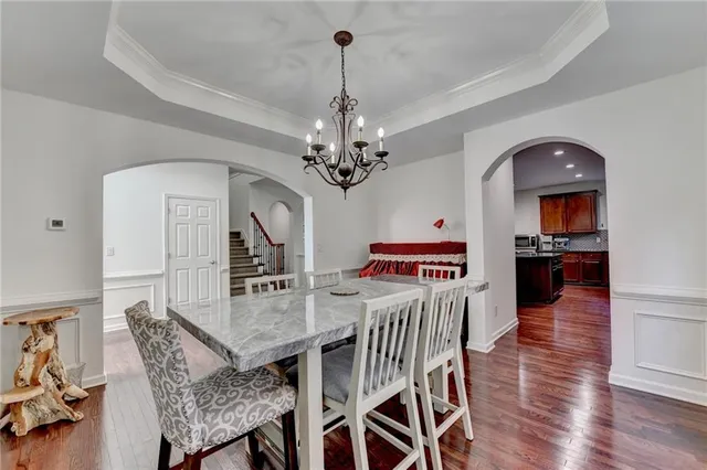 a kitchen with stainless steel appliances granite countertop a refrigerator a stove top oven a sink dishwasher and white cabinets with wooden floor