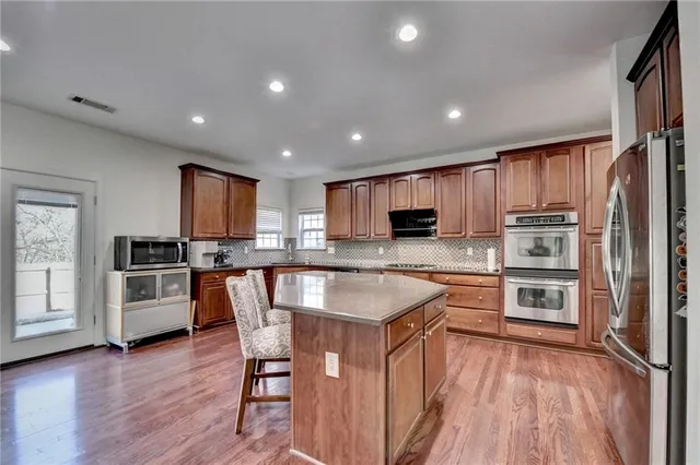 an open kitchen with wooden floor and large kitchen