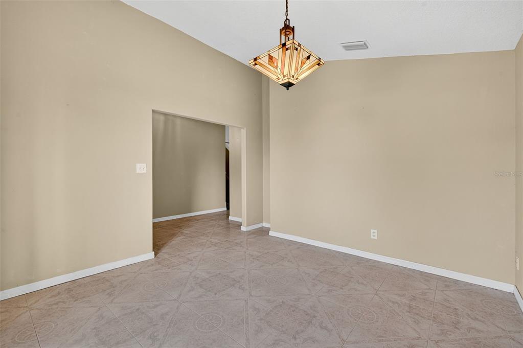 148 Lookout Drive Apollo Beach, FL 33572 - Photo 19 of 71 an empty room with a chandelier fan and wooden floor