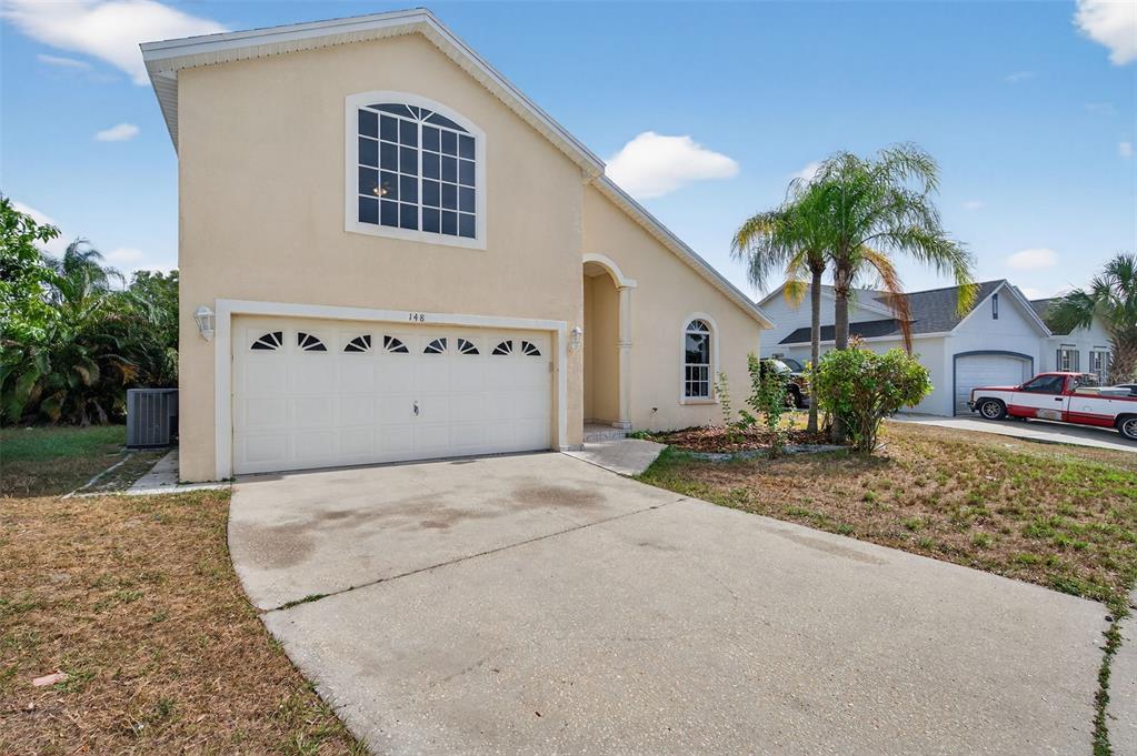 148 Lookout Drive Apollo Beach, FL 33572 - Photo 3 of 71 a front view of a house with a yard and garage
