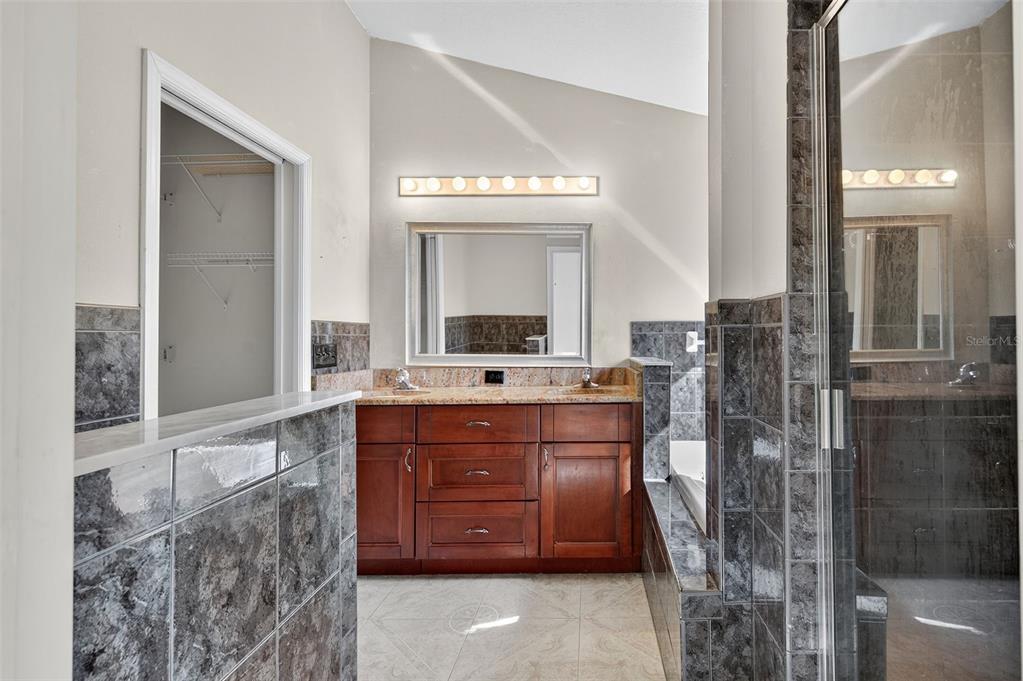 148 Lookout Drive Apollo Beach, FL 33572 - Photo 54 of 71 a bathroom with a granite countertop sink a mirror and a shower