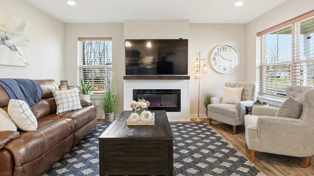 a living room with furniture a flat screen tv and a fireplace