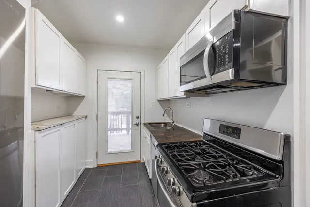 a kitchen with stainless steel appliances granite countertop a stove and a microwave