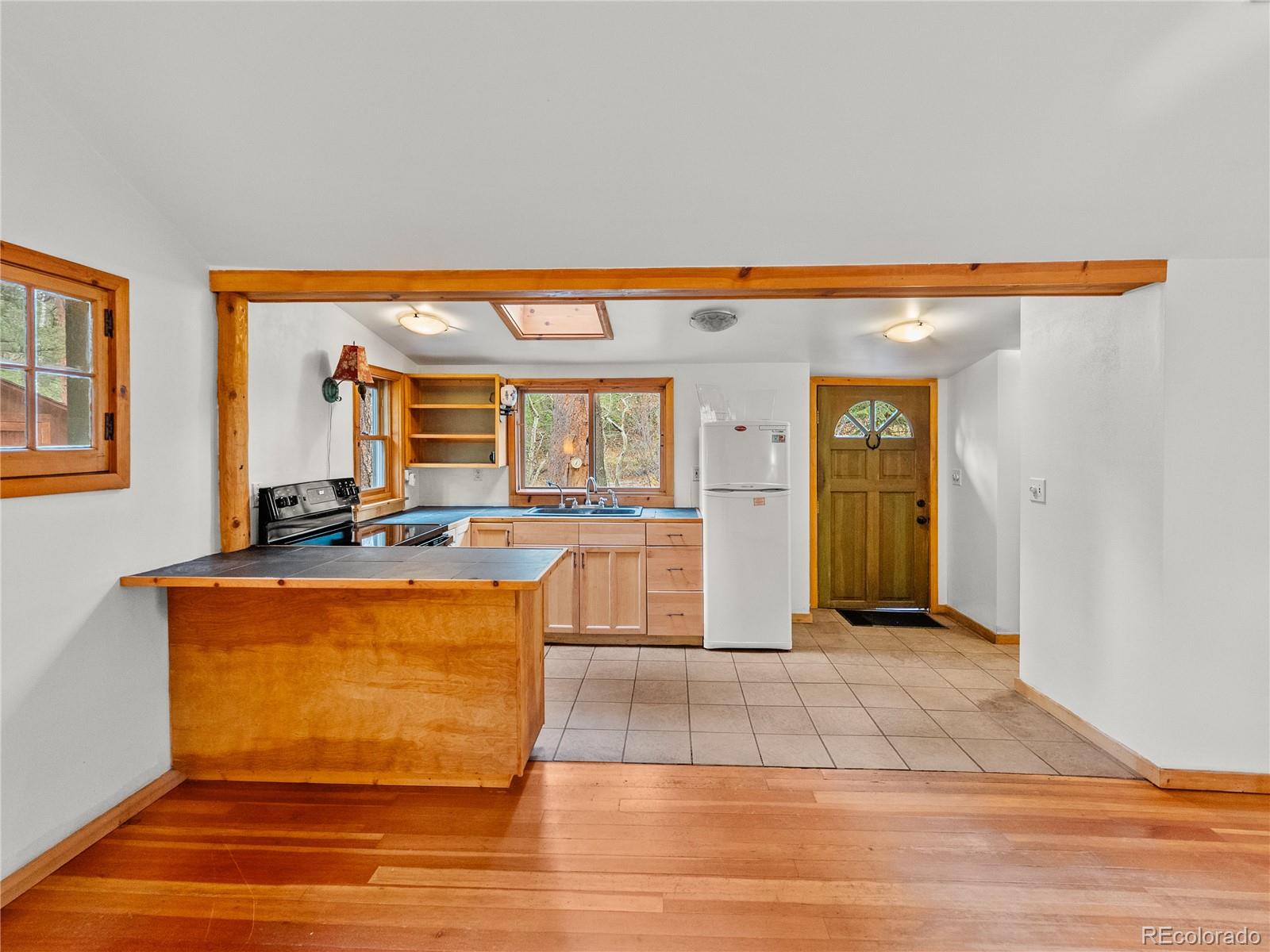 10853 Twin Spruce Road Golden, CO 80403 - Photo 19 of 32 a living room with a couch and a table with wooden floor