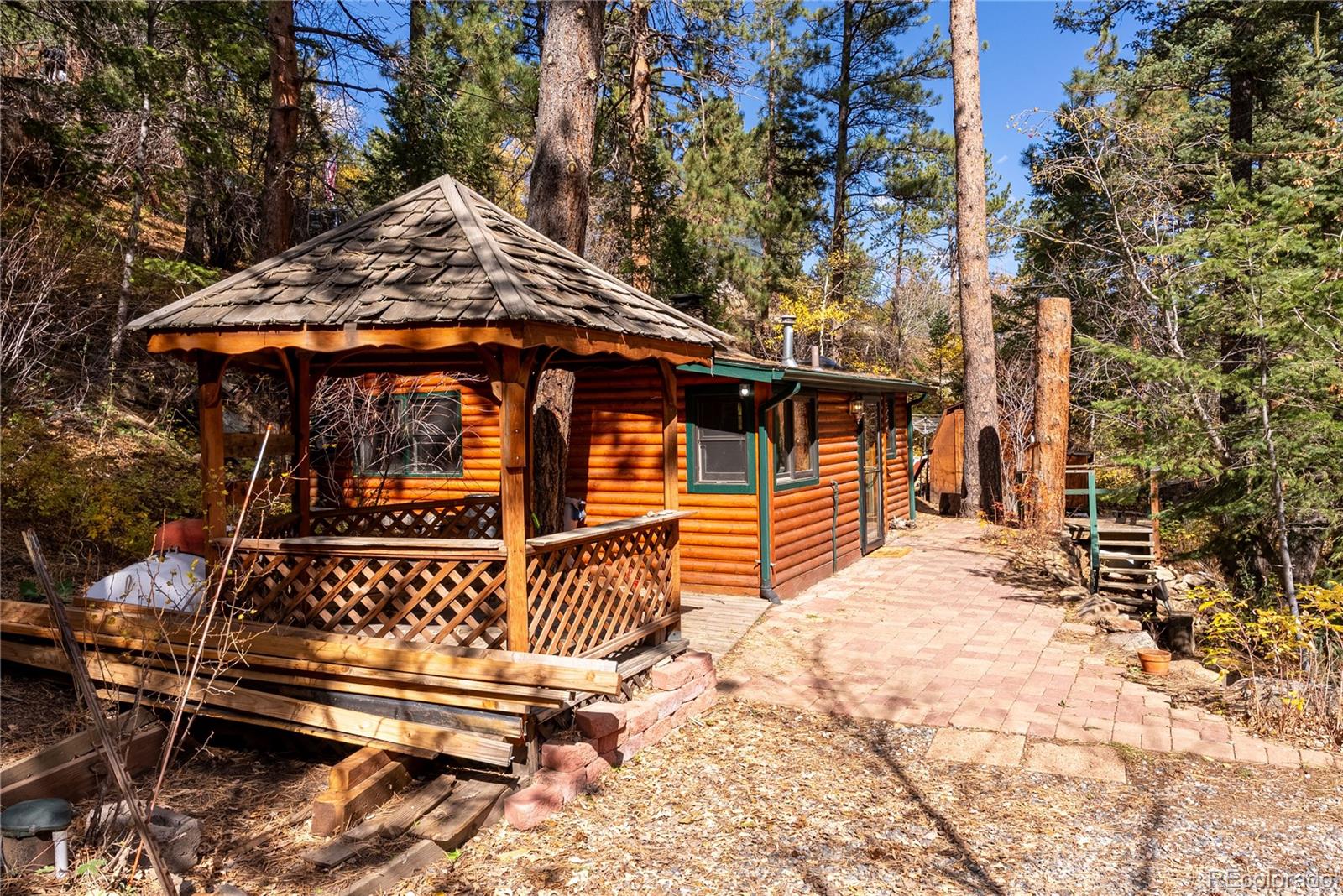 10853 Twin Spruce Road Golden, CO 80403 - Photo 2 of 32 a blue and white top of a house with a large tree