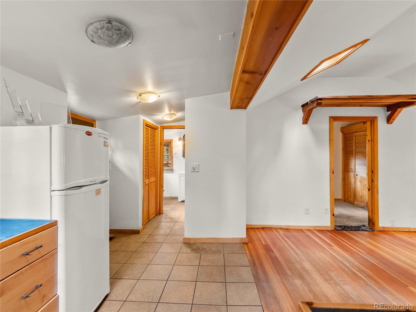 10853 Twin Spruce Road Golden, CO 80403 - Photo 22 of 32 a view of a kitchen with a refrigerator cabinet and a fireplace