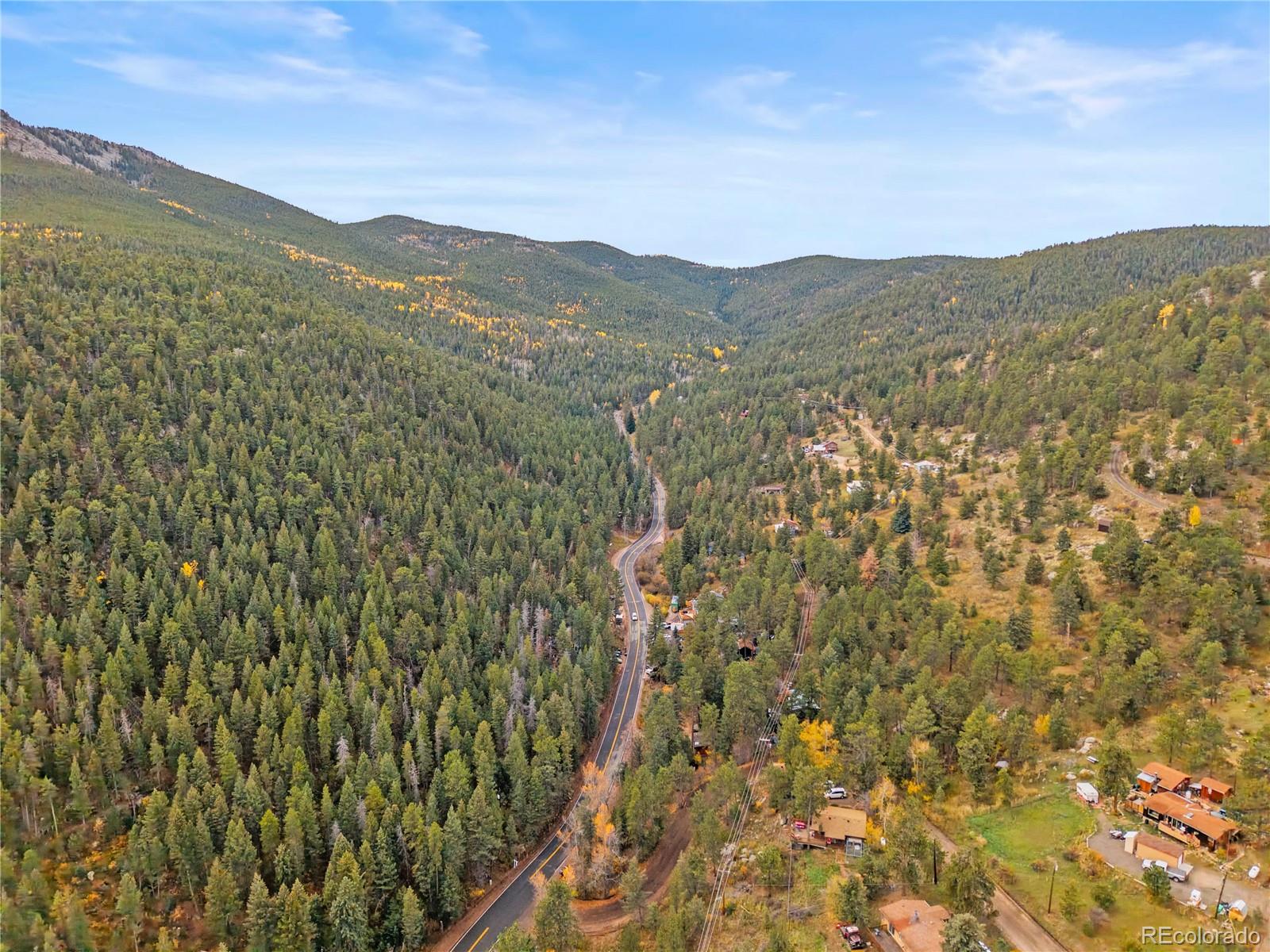10853 Twin Spruce Road Golden, CO 80403 - Photo 30 of 32 a view of a mountain range with a lush green hillside