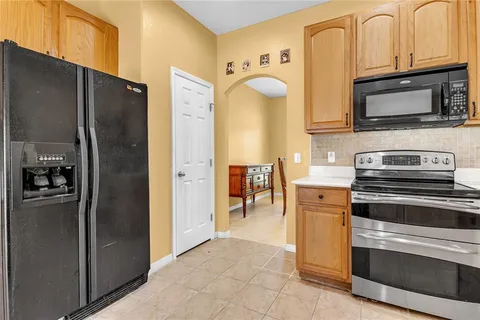 a kitchen with stainless steel appliances granite countertop a refrigerator and a stove top oven