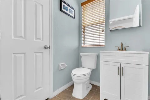 a bathroom with a sink toilet and a window