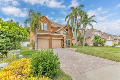 a front view of a house with a garden and trees