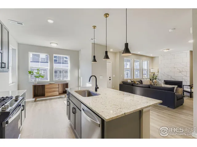 a kitchen with stainless steel appliances kitchen island granite countertop a sink a counter top space and living room view