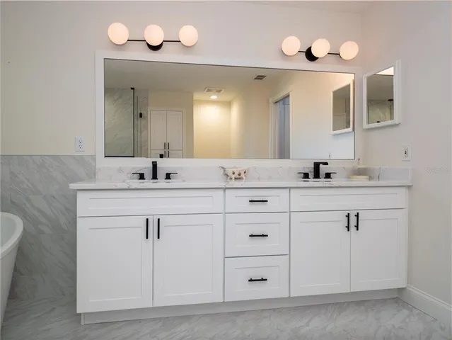 a bathroom with a sink vanity and a mirror
