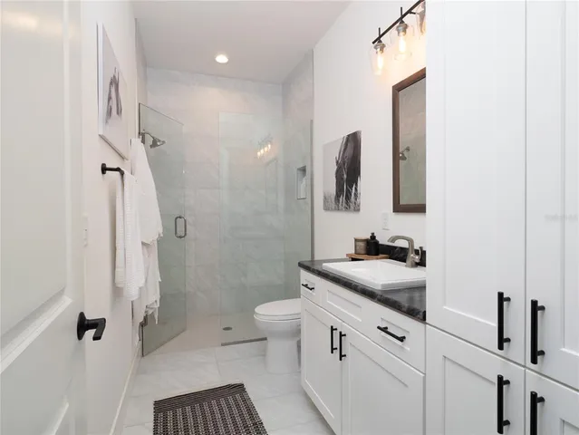 a bathroom with a sink a toilet and shower