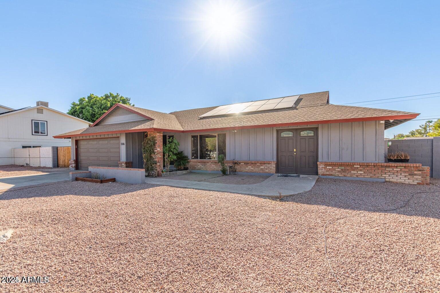1316 North Spring Circle Mesa, AZ 85203 - Photo 1 of 14 a front view of a house with a yard and garage