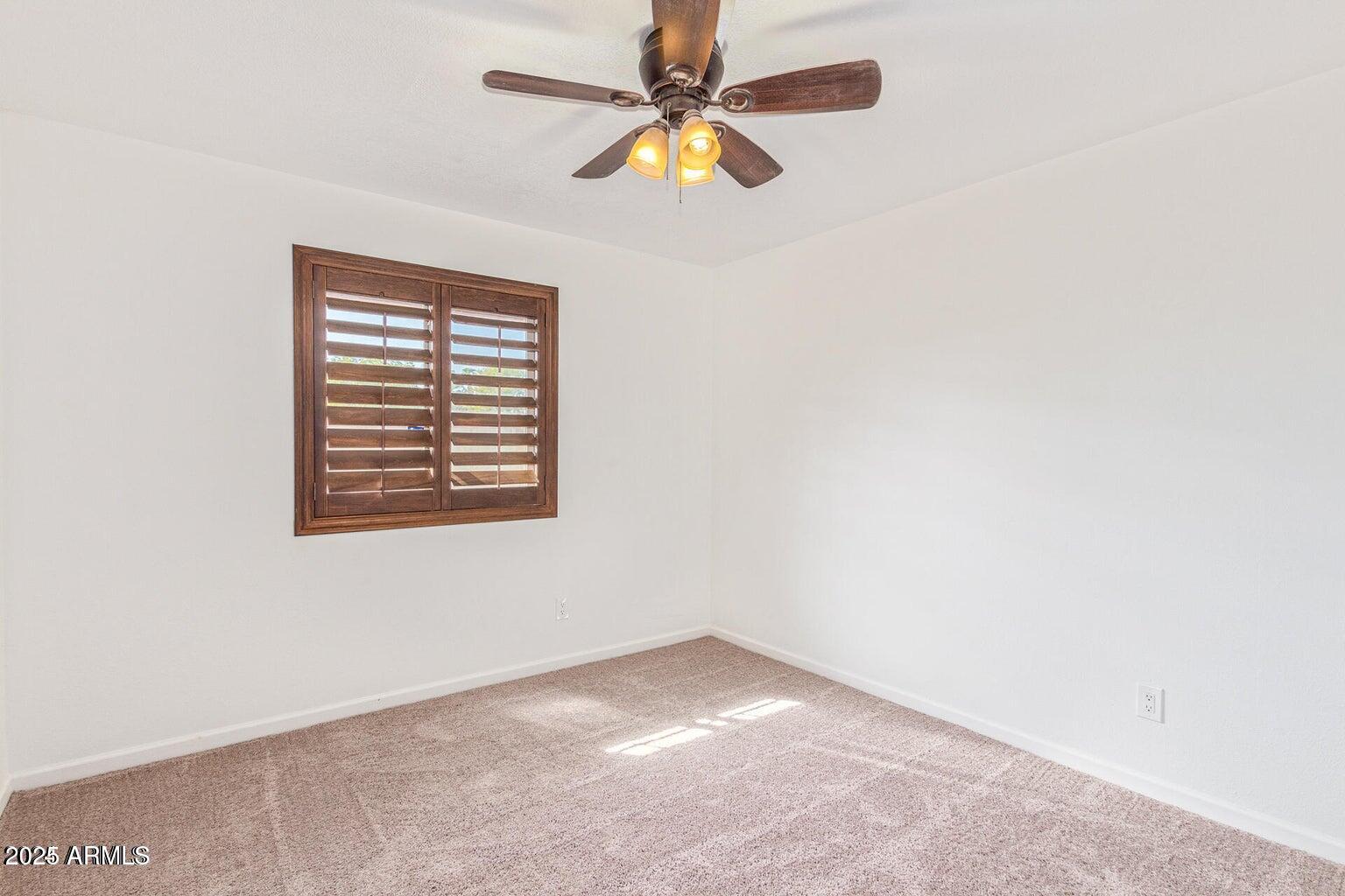 1316 North Spring Circle Mesa, AZ 85203 - Photo 11 of 14 an empty room with a window and a fan