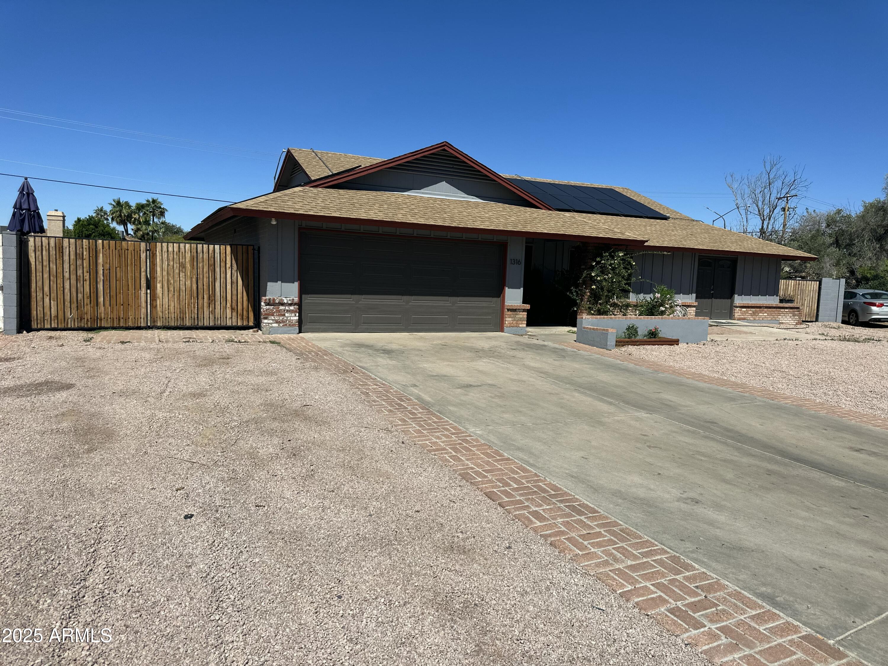 1316 North Spring Circle Mesa, AZ 85203 - Photo 2 of 14 a front view of a house with a yard and garage