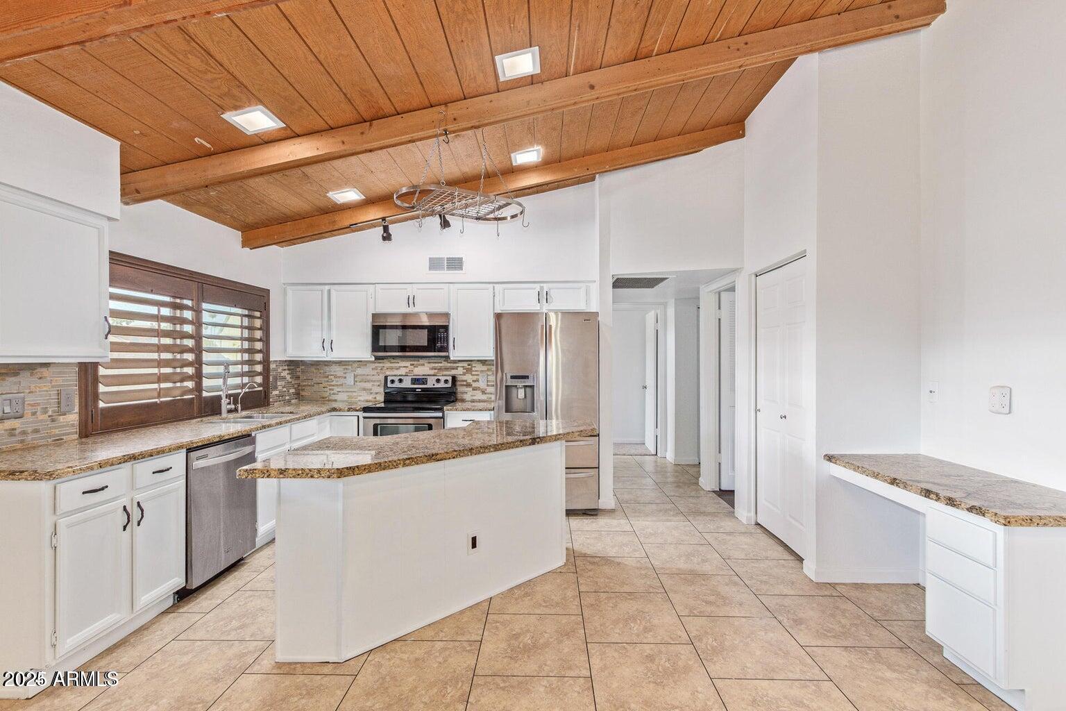 1316 North Spring Circle Mesa, AZ 85203 - Photo 5 of 14 a large kitchen with stainless steel appliances kitchen island granite countertop a sink and cabinets