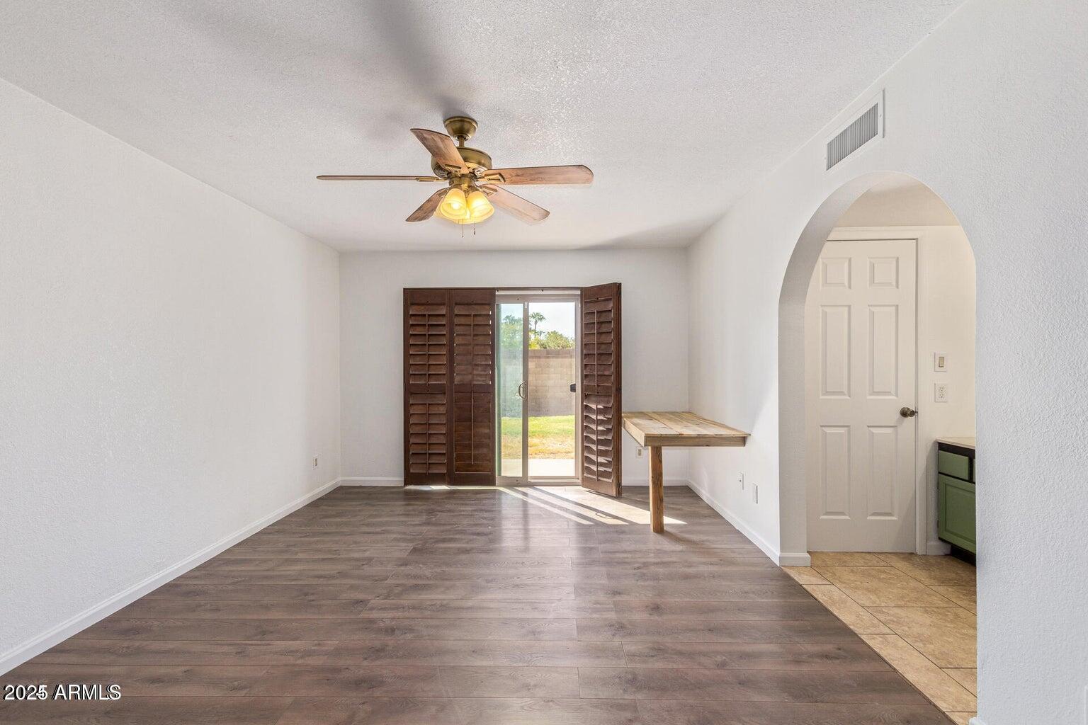 1316 North Spring Circle Mesa, AZ 85203 - Photo 8 of 14 a view of an empty room with a window and wooden floor