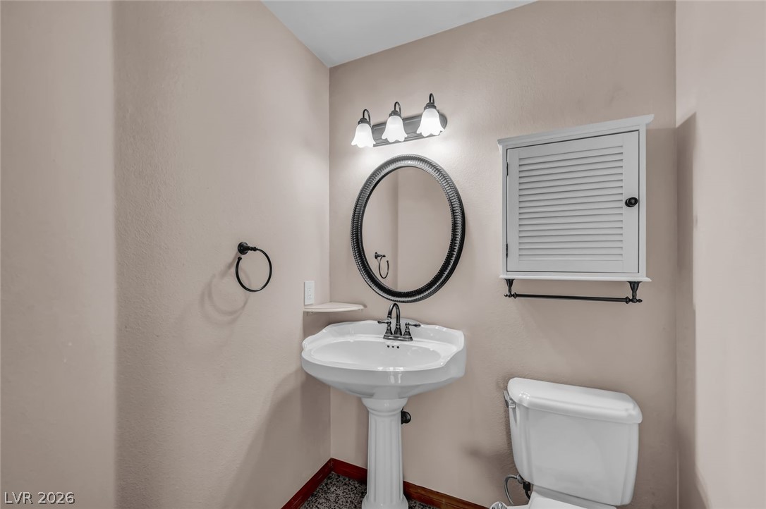 640 North Racetrack Road Henderson, NV 89015 - Photo 28 of 65 A well-appointed powder room features a classic pedestal sink and ample vanity lighting.