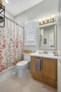 a bathroom with a tub a double vanity sink and a large mirror