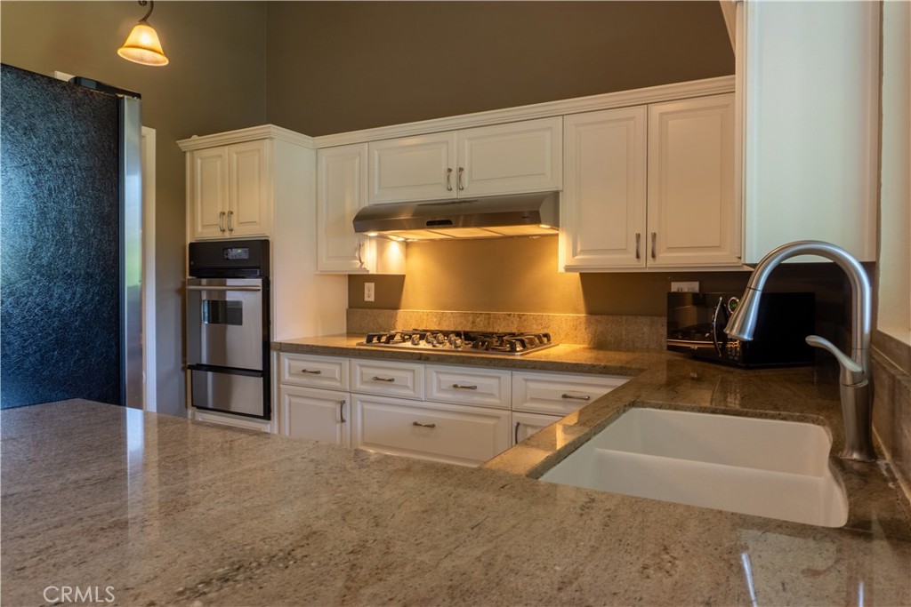 2154 Vista Entrada Newport Beach, CA 92660 - Photo 7 of 19 a kitchen with granite countertop a stove a sink and a refrigerator