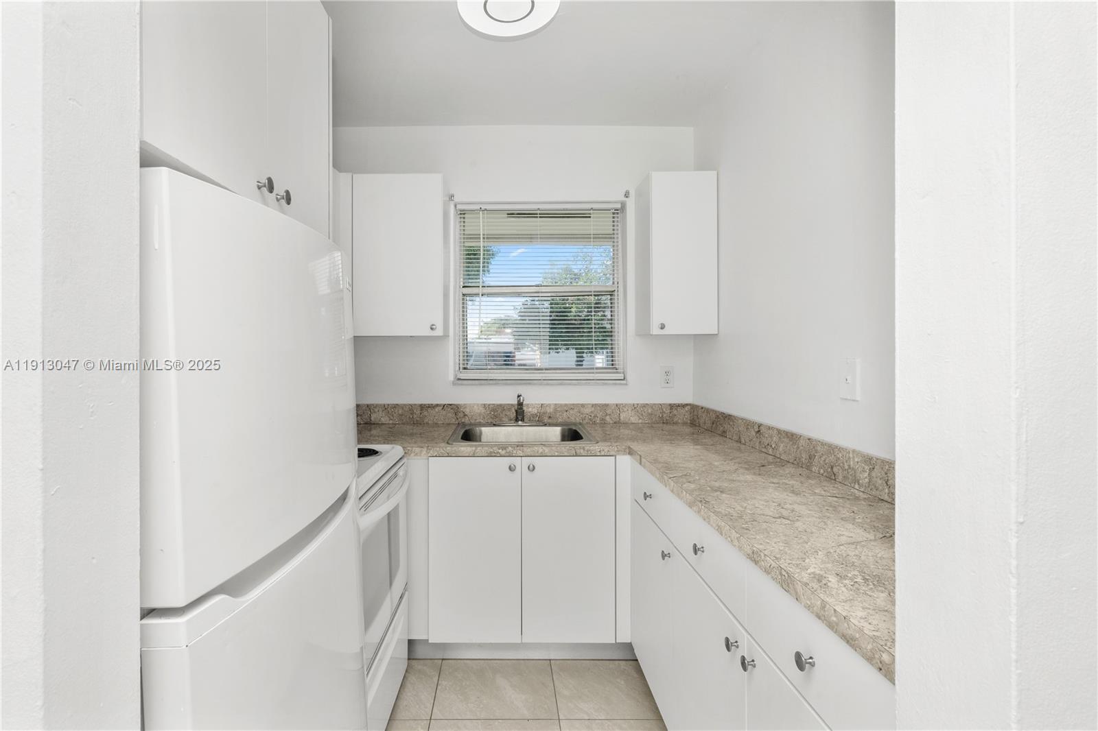 856 Southwest 10th Street, Unit 1 Hallandale Beach, FL 33009 - Photo 8 of 15 a kitchen with a sink stove and cabinets