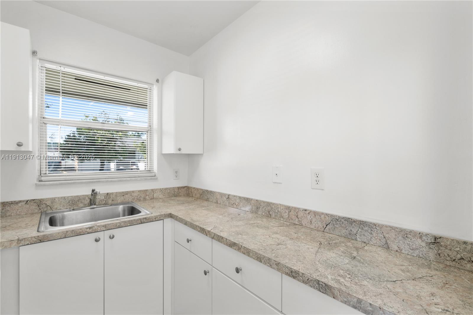 856 Southwest 10th Street, Unit 1 Hallandale Beach, FL 33009 - Photo 10 of 15 a kitchen with a sink cabinets and window