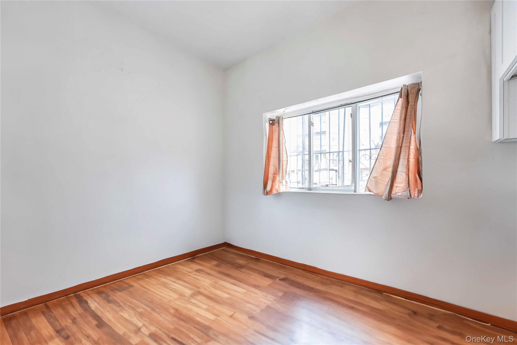 55-14 98th Street Queens, NY 11368 - Photo 15 of 49 an empty room with wooden floor and windows