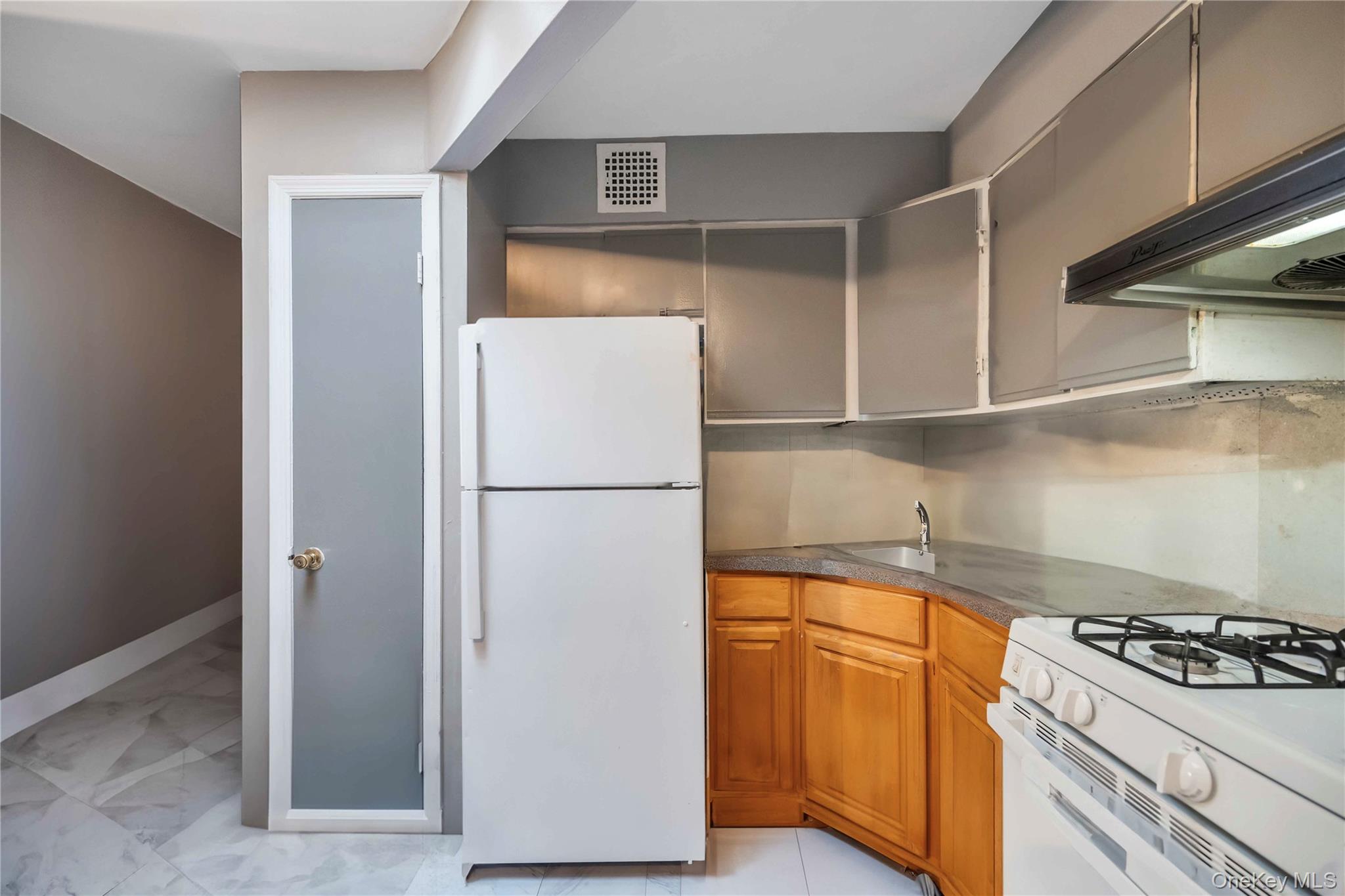 55-14 98th Street Queens, NY 11368 - Photo 43 of 49 a kitchen with refrigerator a stove a sink and cabinets