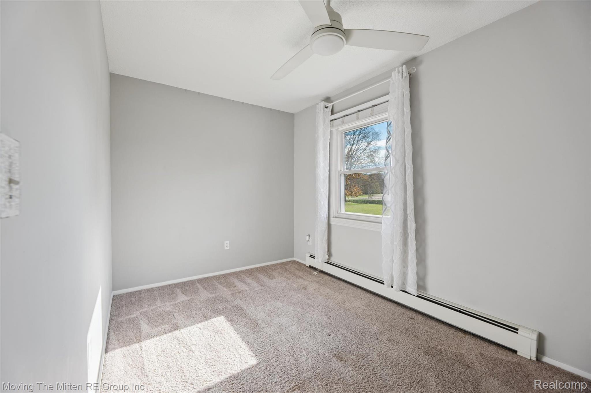 12000 Plank Road Milan, MI 48160 - Photo 21 of 49 Empty room with light colored carpet, a baseboard radiator, and a ceiling fan