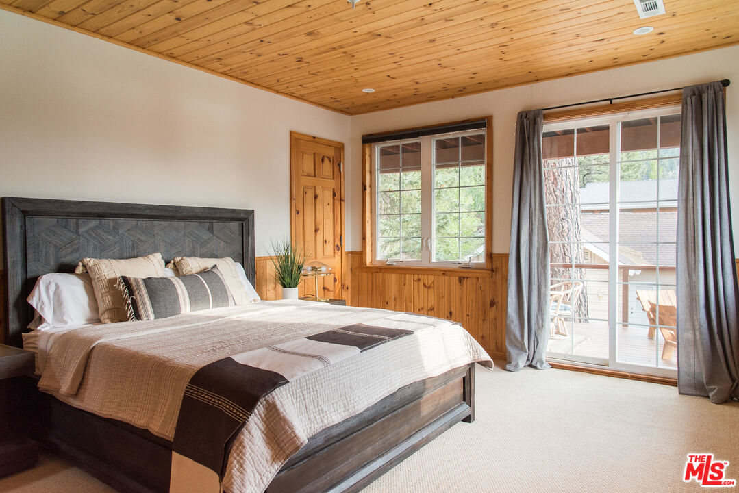 668 Cove Drive Big Bear Lake, CA 92315 - Photo 21 of 31 a spacious bedroom with a bed and a large window