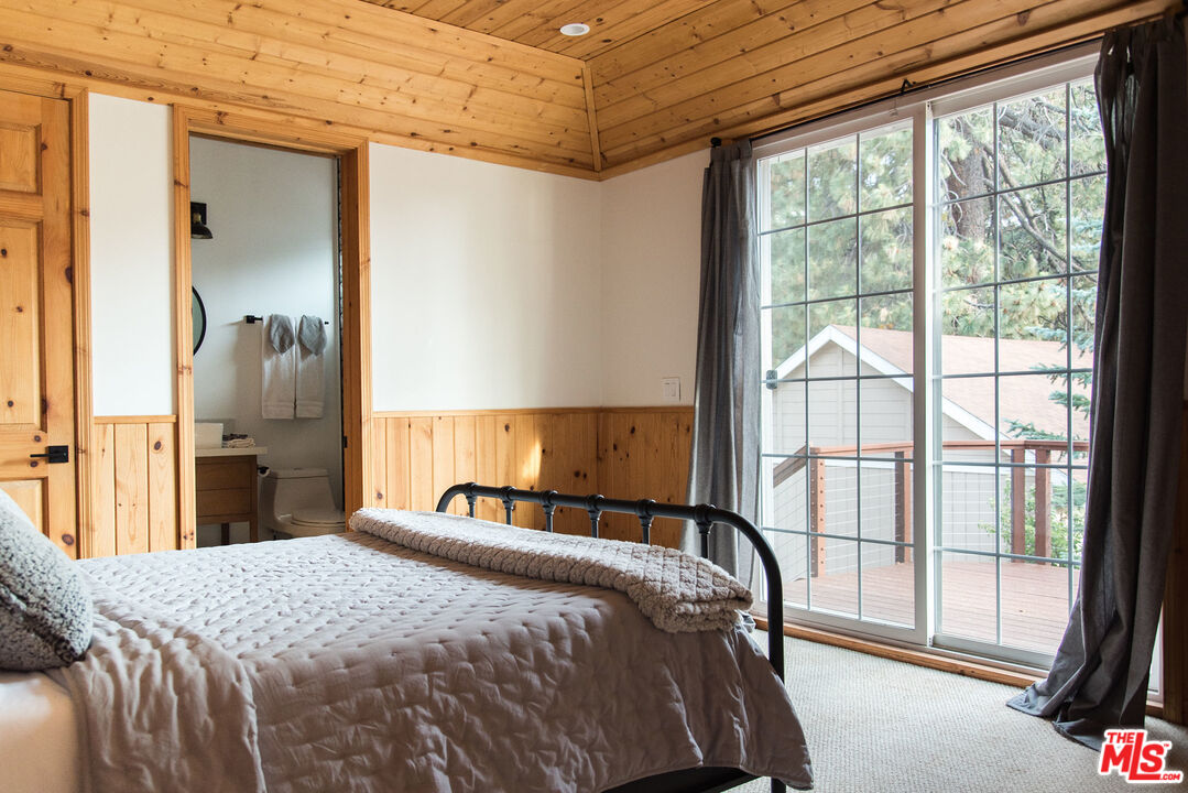 668 Cove Drive Big Bear Lake, CA 92315 - Photo 24 of 31 a bedroom with a bed and a large window