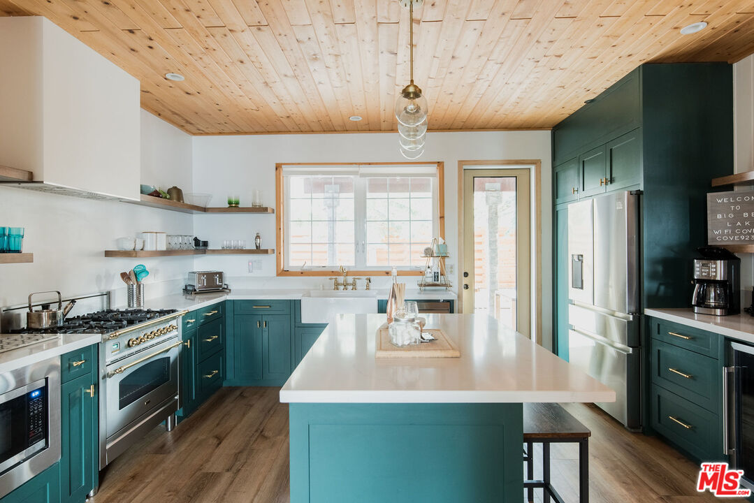 668 Cove Drive Big Bear Lake, CA 92315 - Photo 5 of 31 a kitchen with a sink a stove cabinets and wooden floor