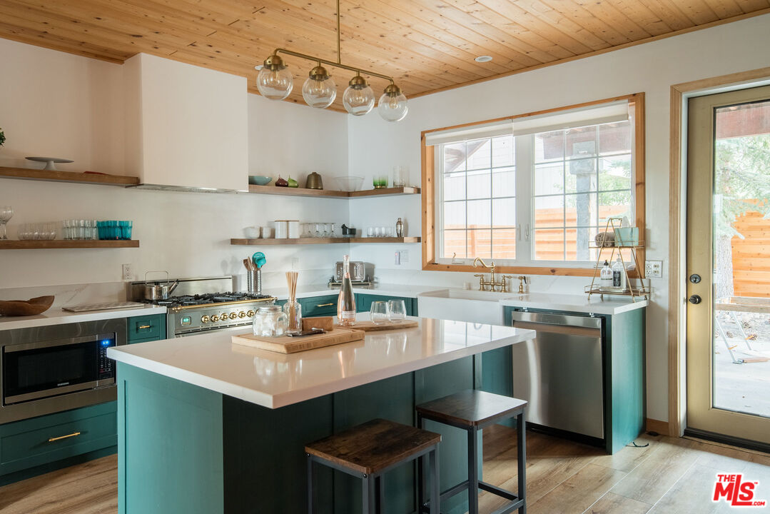 668 Cove Drive Big Bear Lake, CA 92315 - Photo 8 of 31 a kitchen with stainless steel appliances a sink stove and window