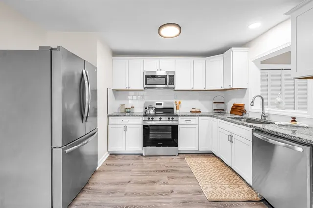 a kitchen with a refrigerator stove top oven and sink