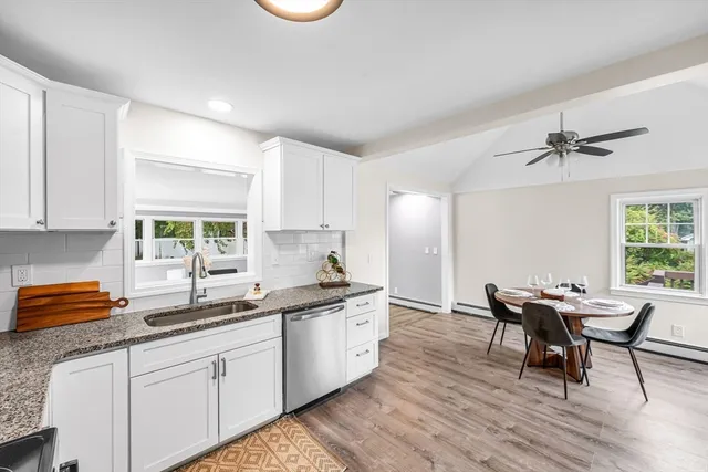 a kitchen with stainless steel appliances granite countertop a sink and wooden floors