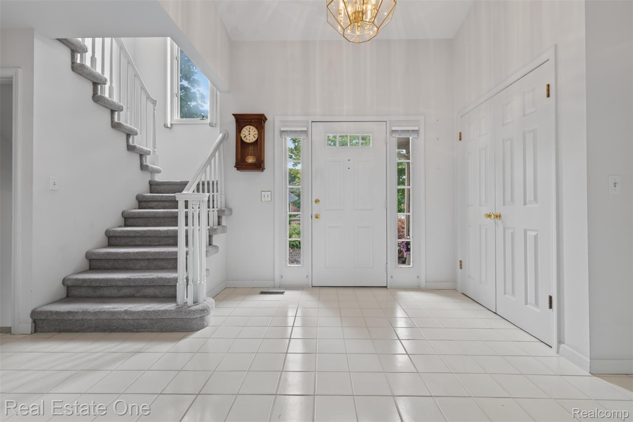 3400 Wedgewood Drive Rochester, MI 48306 - Photo 3 of 49 Bright entryway featuring a white paneled front door with sidelights, a transom window, and chandelier
