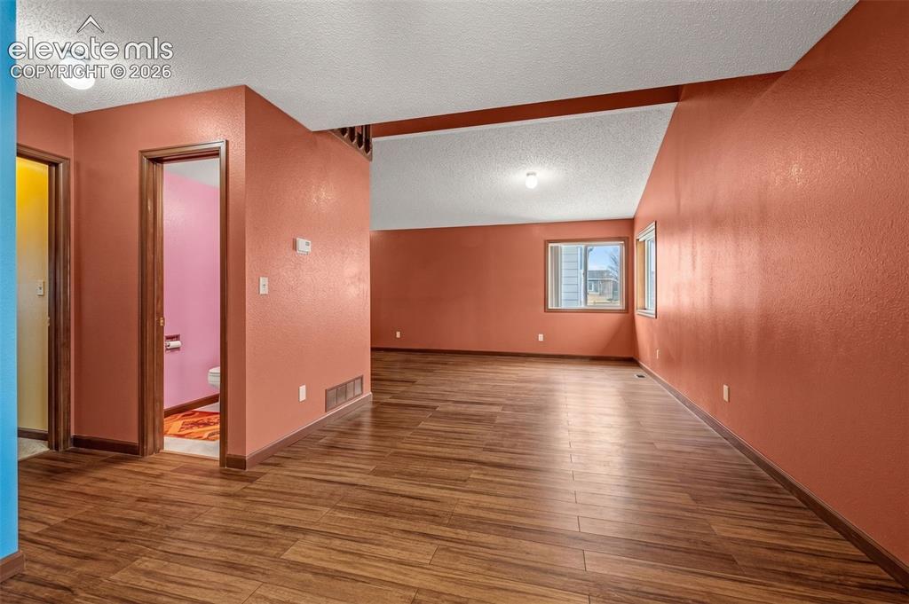 613 Wheat Field Road Fountain, CO 80817 - Photo 5 of 32 a view of an empty room with window and wooden floor