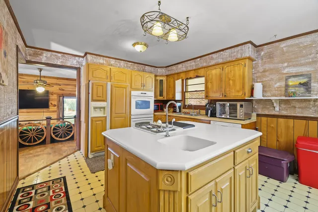 an empty room with a chandelier fan and a window