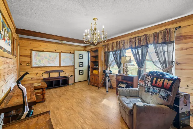 a living room with furniture a flat screen tv and a floor to ceiling window