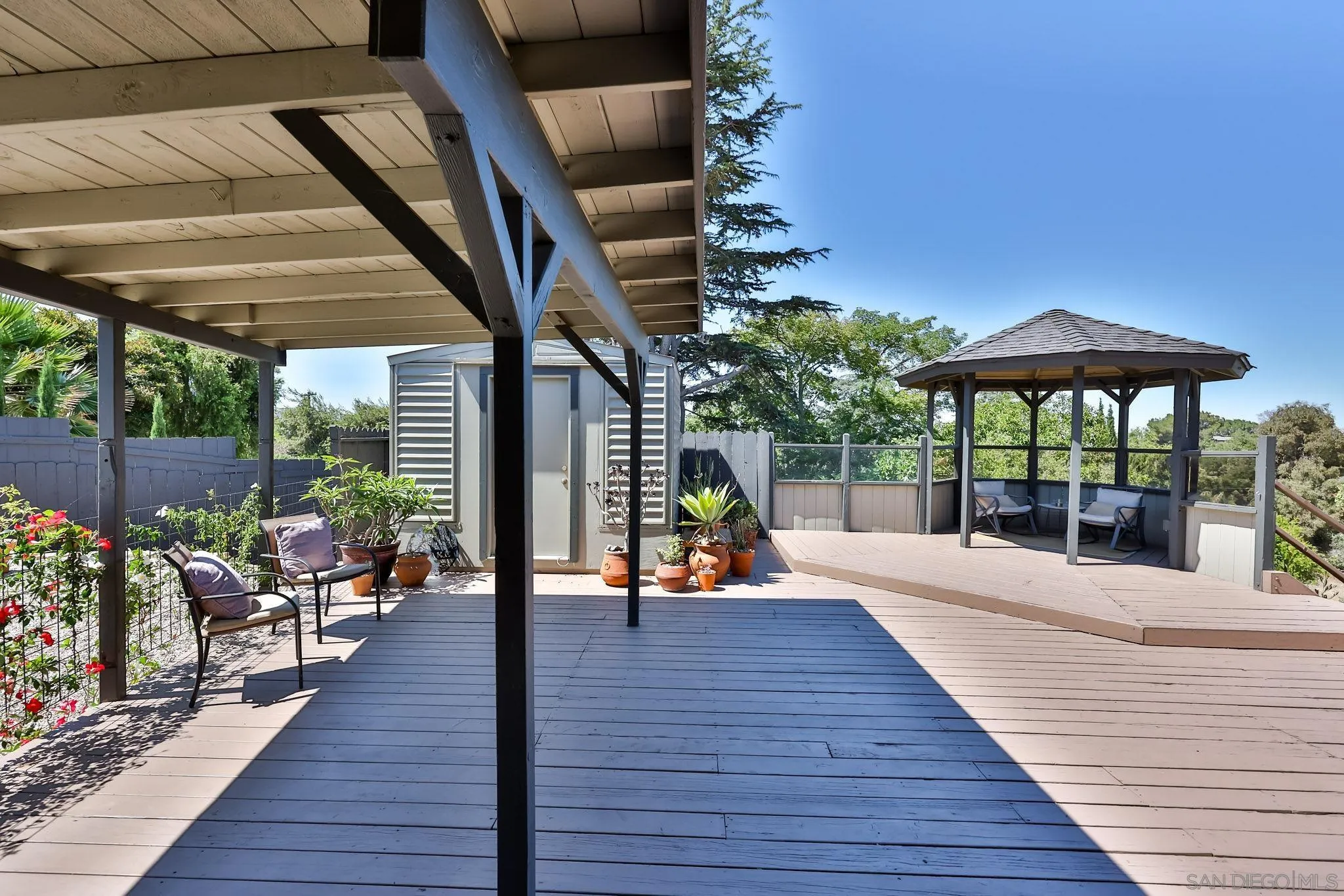 10993 Explorer Road La Mesa, CA 91941 - Photo 22 of 34 a view of a patio with a dining table and chairs under an umbrella with wooden floor